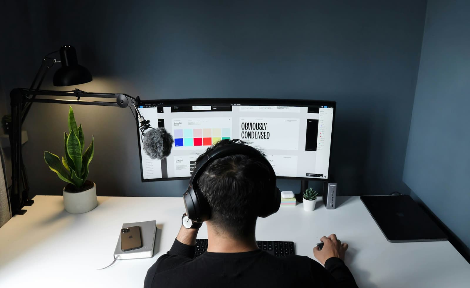 A designer working on a brand style guide at a wide monitor