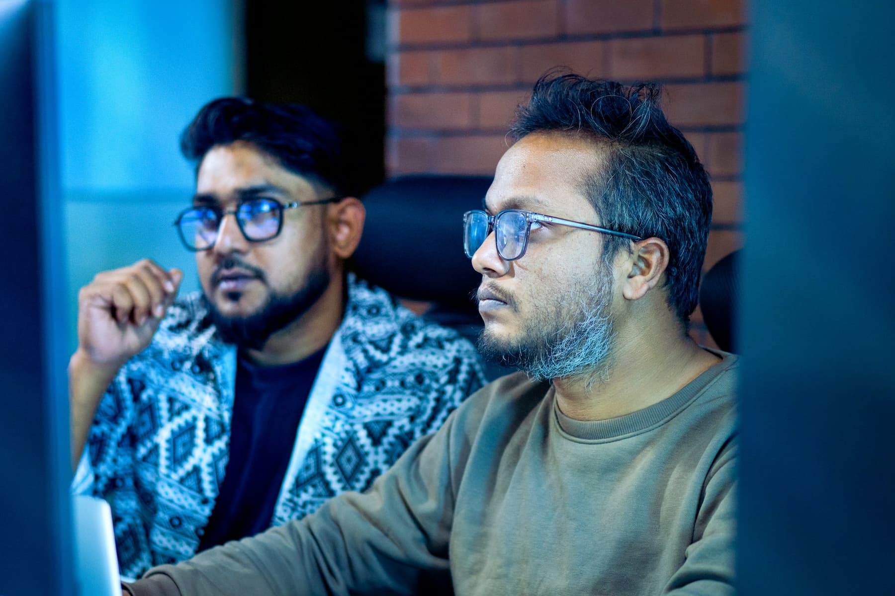 Two engineers working through a fix together at one desk